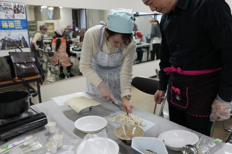 Una participante corta pasteles de arroz en un taller de elaboración de tteokguk organizado por el Centro Cultural Coreano en Osaka, Japón, el 4 de febrero, para celebrar el Año Nuevo Lunar. | CCC en Osaka