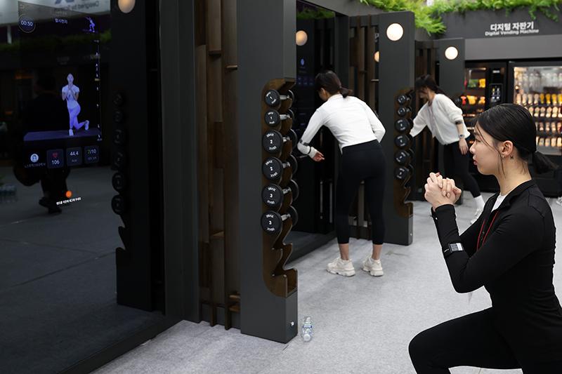 El 22 de febrero, una entrenadora lleva a cabo una demostración de entrenamiento personalizado guiado por un espejo digital inteligente que incorpora tecnología informática en la sala de exposiciones DRAX, durante la Exposición Internacional de la Industria del Deporte y el Ocio de Seúl 2024, también conocido como SPOEX, en el centro de convenciones COEX, en el distrito de Gangnam-gu, Seúl.