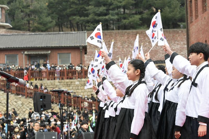 La foto muestra a los estudiantes ondeando la bandera nacional coreana durante el evento 