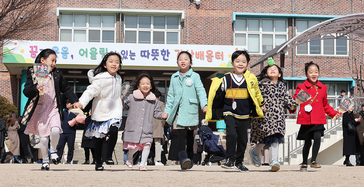 En la mañana del 4 de marzo, los nuevos estudiantes corren a saludar sus padres mientras se toman de la mano de sus amigos, luego de finalizar la ceremonia de ingreso, celebrada en la Escuela Primaria Galsan, ubicada en el distrito de Yangcheon-gu, en Seúl.