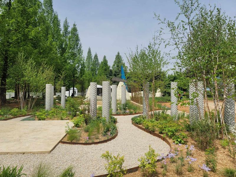 La foto muestra 'Green Oice', el jardín del artista británico Paul Hervey-Brookes, que fue creado con una combinación limitada de materiales duros, como estructuras rugosas de tubos de hormigón, formas curvas de barras de refuerzo y pavimento de grava, para crear una profunda sensación de estabilidad en armonía con las plantas verdes.
