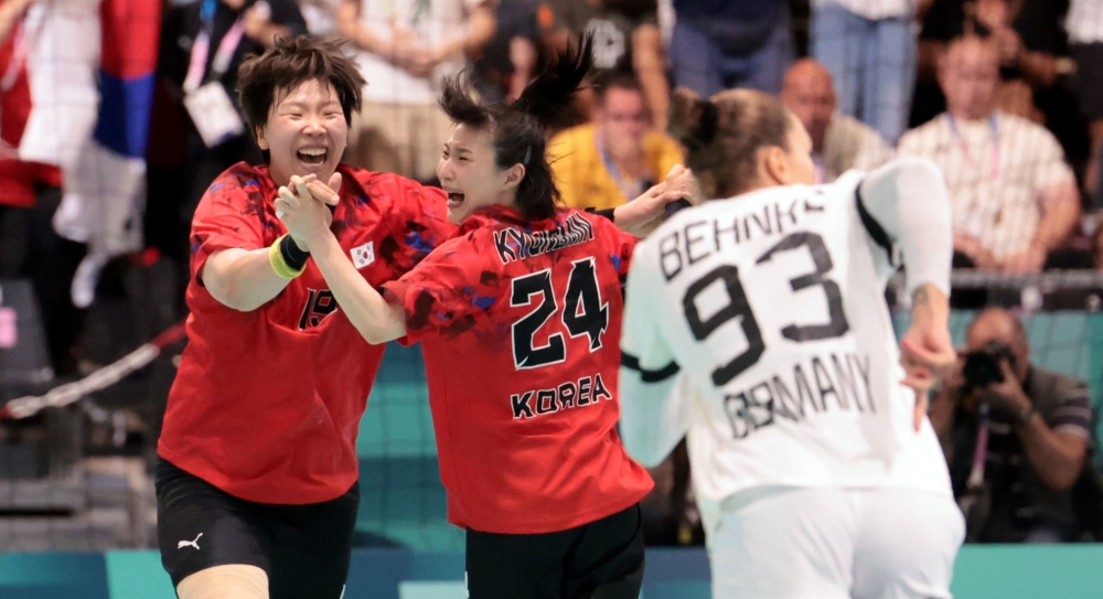 Las jugadoras del equipo coreano de balonmano celebran tras marcar un gol en la segunda parta de un partido contra Alemania, en los Juegos Olímpicos de París 2024, disputado el 25 de julio (hora local), en la víspera de la ceremonia de inauguración del evento, en el estadio París Sur Arena, en la capital francesa.
