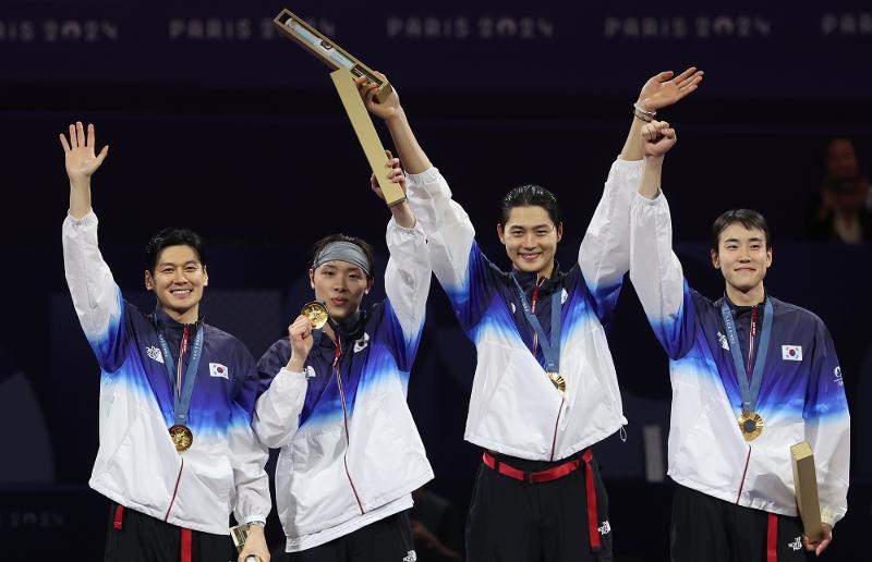 El 31 de julio (hora local), los atletas coreanos Gu Bon-gil, Park Sang-won, Oh Sang-uk y Do Gyeong-dong (de izda. a dcha.) celebran tras ganar la medalla de oro en la prueba de sable por equipos masculino de los Juegos Olímpicos de París 2024, en el Gran Palacio de la capital francesa.