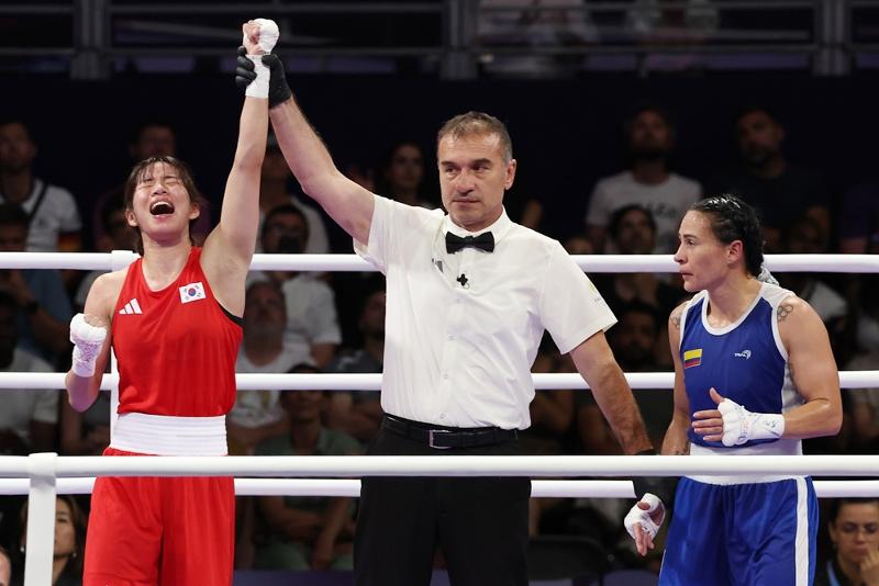 El 1 de agosto (hora local), la boxeadora coreana Im Ae-ji (izda.) celebra tras vencer a la colombiana Yeni Marcela Arias Castañeda en los cuartos de final de la categoría de 54 kilogramos de boxeo femenino, en los Juegos Olímpicos de París, en el París Norte Arena, en la capital francesa. | Agencia de Noticias Yonhap