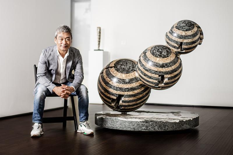La foto muestra al escultor y artista coreano Park Eun Sun posando para una foto al lado de una de sus piezas de la colección 'Colonna Infinita -Accrescimento'. | Art of the World Gallery
