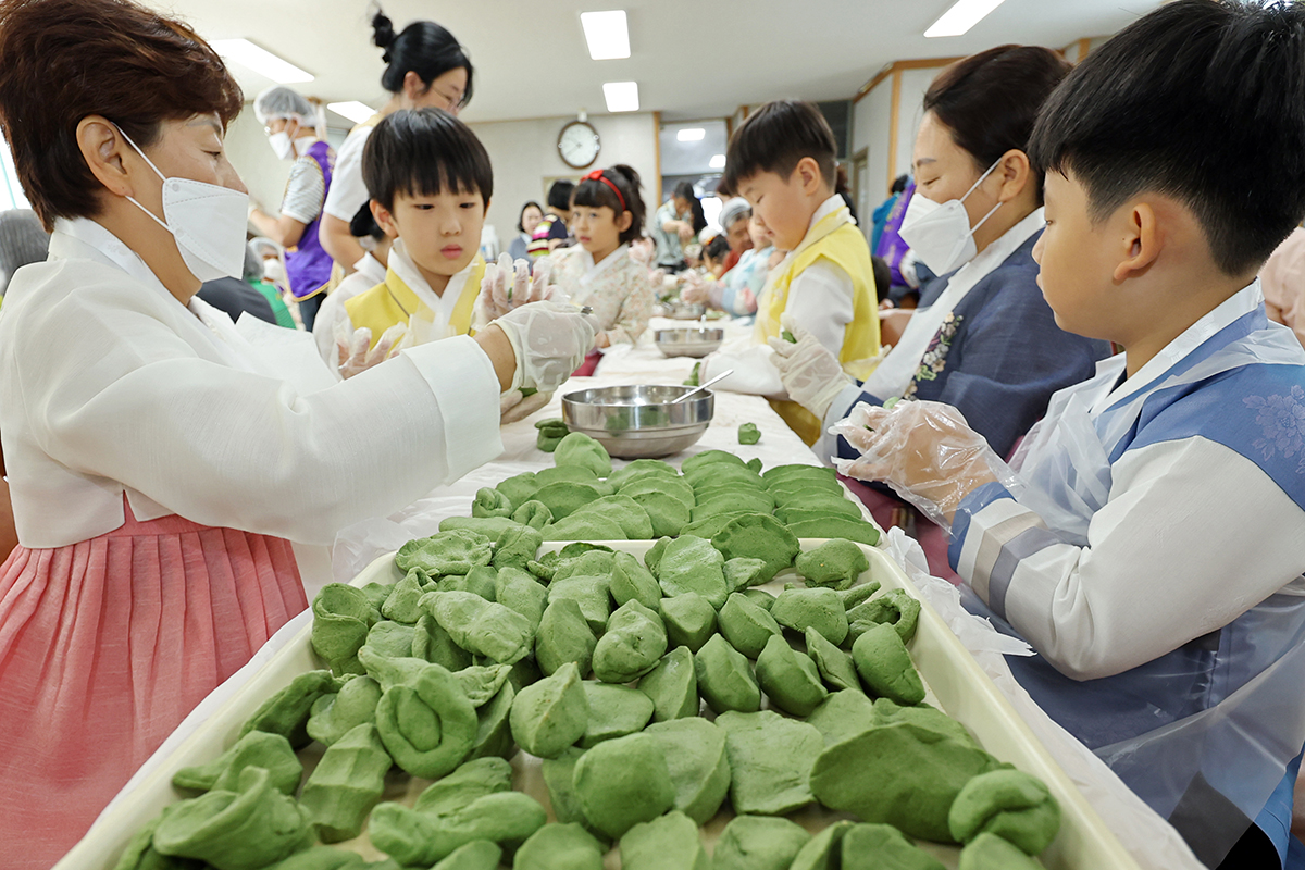 El 10 de septiembre, unos niños participan en un taller para hacer songpyeon, los pasteles de arroz al vapor rellenos con frijoles dulces que se comen tradicionalmente durante la fiesta de la cosecha de Chuseok, en el Centro Comunitario del barrio de Ochi 2-dong, en la ciudad de Gwangju.