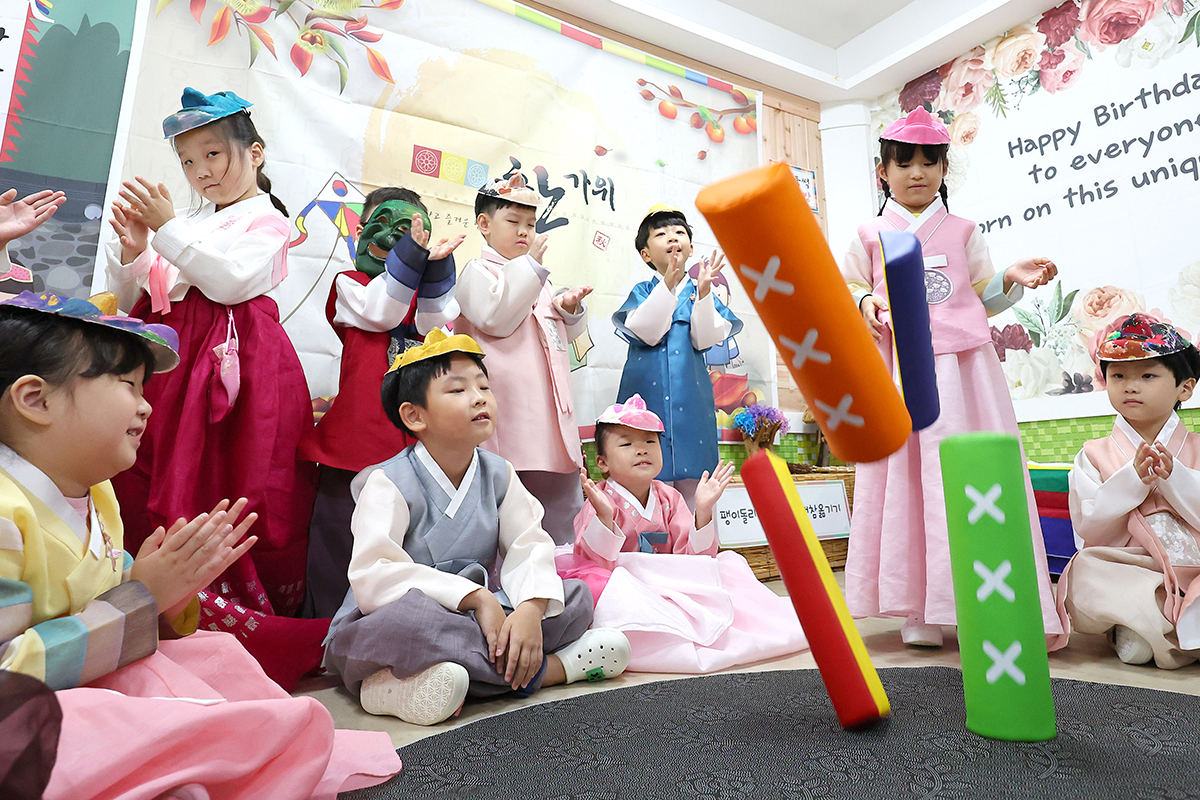 En la mañana del 12 de septiembre, a dos días de las celebraciones del Chuseok, unos estudiantes de primaria vestidos con hanbok juegan Iut, en las instalaciones de su escuela, en el distrito de Bupyeong-gu, en la ciudad de Incheon.