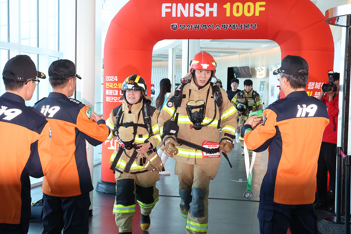 El 30 de octubre, dos bomberos cruzan la línea de meta en el torneo nacional de escalada para bomberos en Haeundae, Busan.