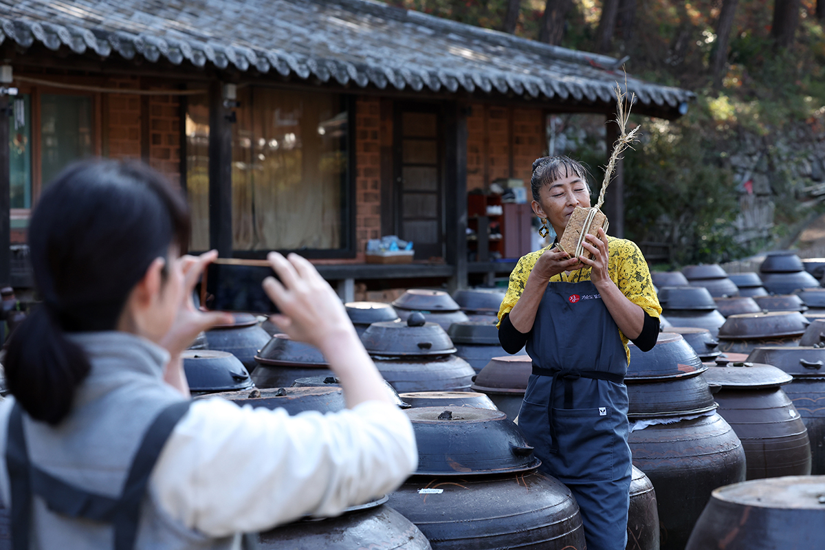 El 13 de noviembre, una turista japonesa posa con meju, bloques de pasta de soja fermentada que hizo durante un taller de elaboración de meju, en la escuela de fermentación Ki Soon-do de Damyang, provincia de Jeollanam-do.