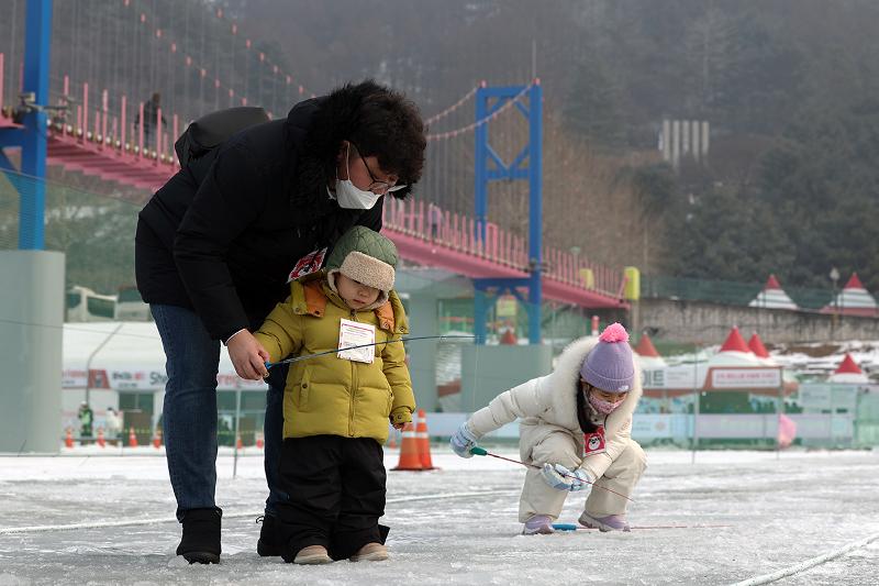 El 14 de enero, una familia intenta pescar truchas en la zona de pesca, durante el Festival de Hielo Hwacheon Sancheoneo, que se está llevando a cabo en el municipio de Hwacheon-eup, en el condado de Hwacheon-gun, provincia de Gangwon-do.