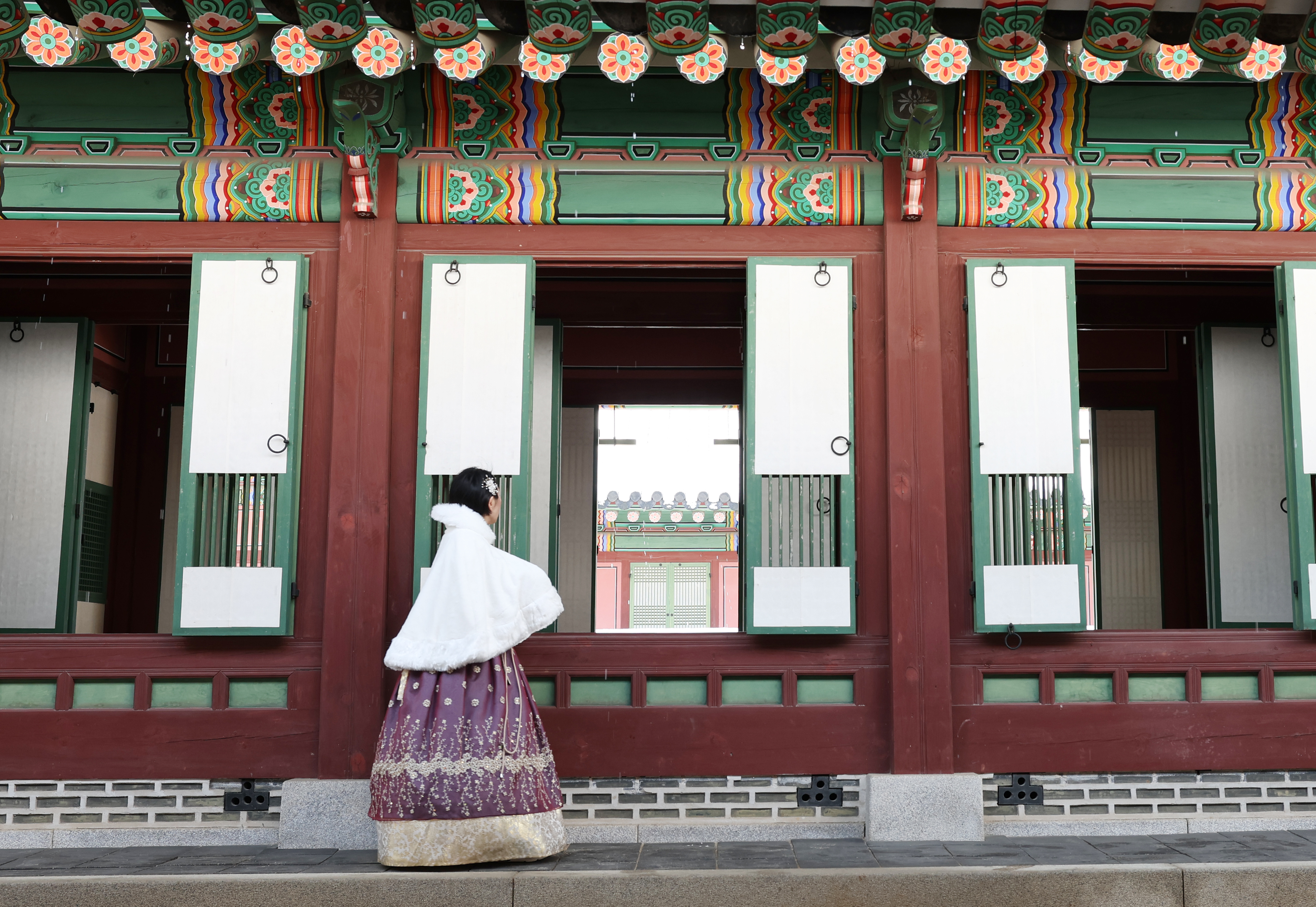 Una visitante vestida con un hanbok explora el interior de un pabellón del palacio Changdeokgung en Seúl durante el evento 