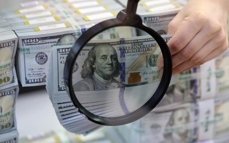 La foto de archivo, tomada el 3 de abril de 2024, muestra a un empleado de banca comprobando los billetes de 100 dólares en el Centro de Respuesta a Billetes Falsos del banco Hana, en el distrito de Jung-gu, Seúl. | Agencia de Noticias Yonhap