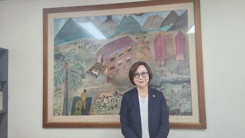 Lee Na-young, presidenta del Consejo Coreano para la Justicia y la Memoria sobre el Problema de la Esclavitud Sexual Militar por Japón, toma una foto frente a un dibujo de la víctima Kang Duk-kyung, el 24 de julio en su despacho.