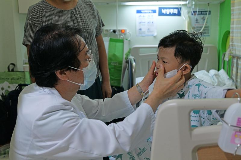 El Dr. Kim Woong-Han, del Departamento de Cirugía Torácica y Cardiovascular Pediátrica del Hospital de la Universidad Nacional de Seúl (SNU, por sus siglas en inglés), examina el 14 de septiembre de 2023 a Sai Ko Ko, un niño de Myanmar (la antigua Birmania) que fue operado en el centro por una cardiopatía congénita. | Hospital SNU