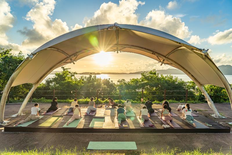 Los participantes del programa Project Rest a While Island practican yoga frente al atardecer en la isla de Ganghwado, Incheon. 