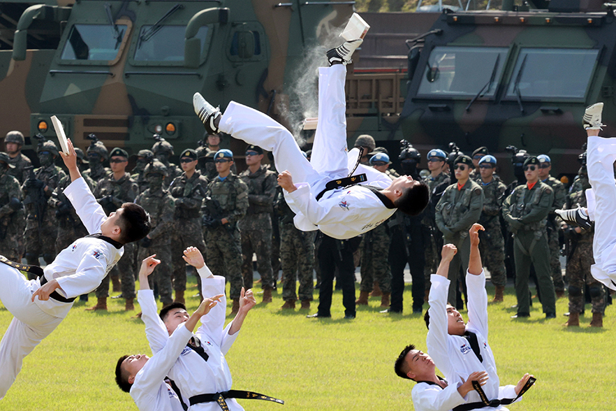 Los integrantes del equipo de demostraci&oacute;n de taekwondo realizan un rompimiento a&eacute;reo con patadas acrob&aacute;ticas durante la ceremonia del 77&ordm; aniversario del D&iacute;a de las Fuerzas Armadas, el 1 de octubre, en el campo de desfile principal del cuartel militar de Gyeryongdae, en Gyeryong, provincia de Chungcheongnam-do.