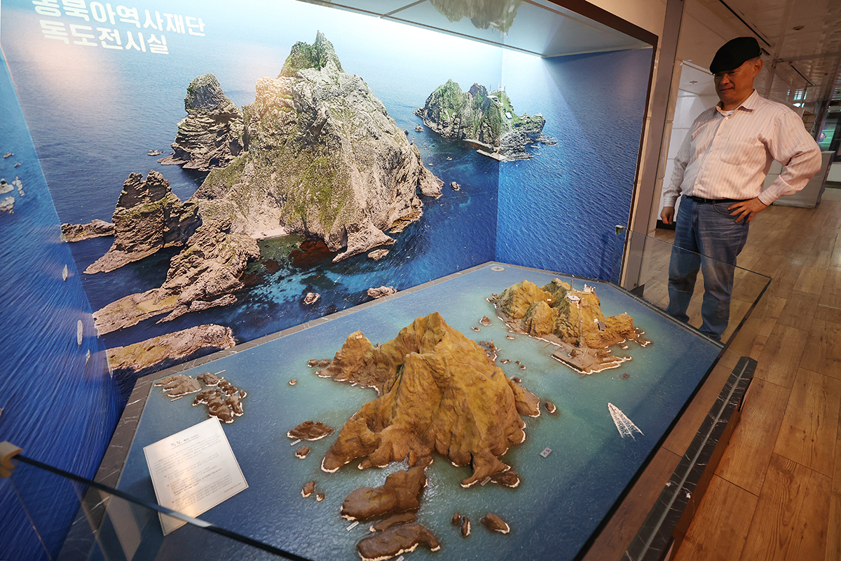 Un visitante observa una réplica de los islotes Dokdo en la Sala de Exposición Permanente de Dokdo, ubicada en la Estación de Gwanghwamun, en el distrito Jongno-gu de Seúl, el 24 de octubre, un día antes del Día de Dokdo.