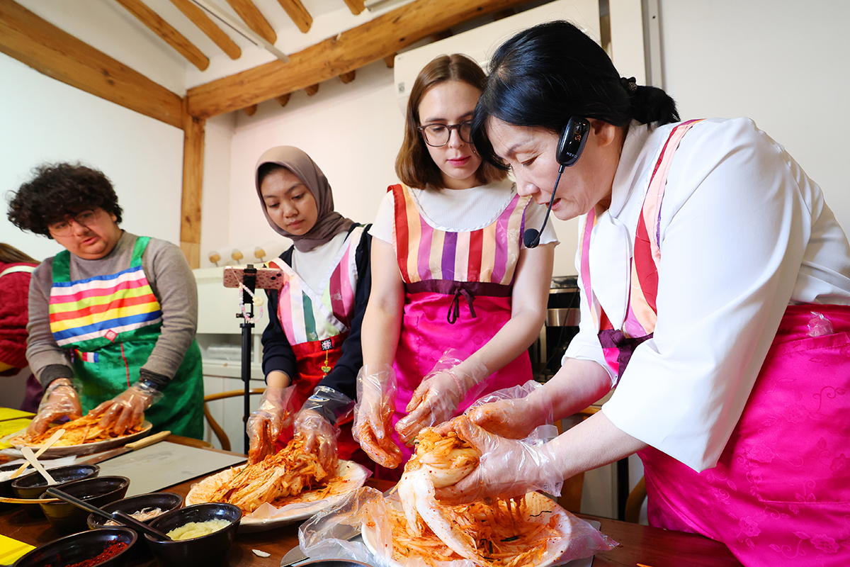 Un grupo de estudiantes extranjeros escucha las explicaciones de una instructora mientras aprende a elaborar el kimchi, el 10 de noviembre, en el Centro de Experiencia Cultural del Kimchi de Seúl, ubicado en el distrito capitalino de Jongno-gu.