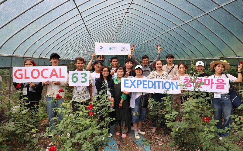 Unos participantes del Glocal 63 Culture Show posan para una foto el 13 de julio en una granja del condado de Eumseong-gun, provincia de Chungcheongbuk-do. | Glocal Town