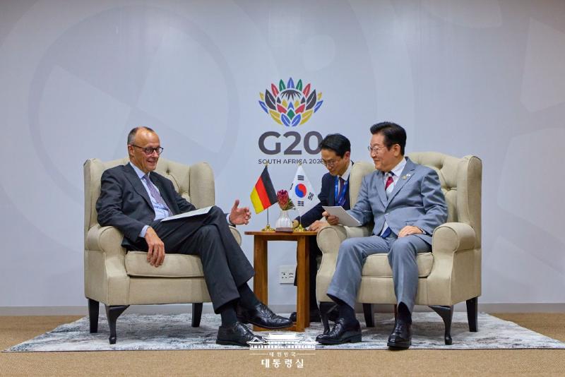 El presidente Lee Jae Myung (derecha) y el canciller alemán Friedrich Merz celebran una reunión bilateral al margen de la cumbre del Grupo de los 20 (G20), el 22 de noviembre (hora local), en el Centro de Exposiciones Nasrec, en Johannesburgo, Sudáfrica.