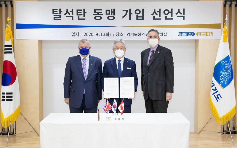La provincia de Gyeonggi-do ha obtenido resultados destacados en la reducción de carbono tras incorporarse a la PPCA en septiembre de 2020. En la imagen, el entonces gobernador de la provincia y actual presidente, Lee Jae Myung (centro) posa el 1 de septiembre de 2020 junto al embajador del Reino Unido en Corea, Simon Smith (izda.) y el embajador de Canadá, Michael Danagher, durante la ceremonia de adhesión a la PPCA en Suwon. | Oficina provincial de Gyeonggi-do