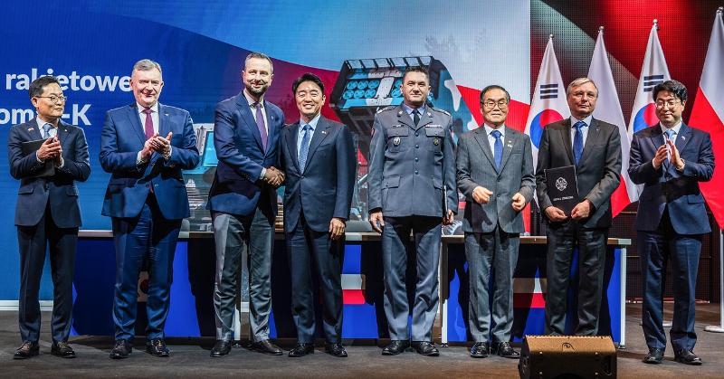 El jefe de Gabinete presidencial, Kang Hoon-sik (4º por la izda.), estrecha la mano del viceprimer ministro y ministro de Defensa Nacional de Polonia, Wladyslaw Kosiniak-Kamysz, durante la ceremonia de firma del tercer contrato de ejecución para el suministro de misiles guiados Chunmoo de Corea, celebrada el 29 de diciembre (hora local) en el Museo del Ejército Polaco, en Varsovia. | Hanwha Aerospace