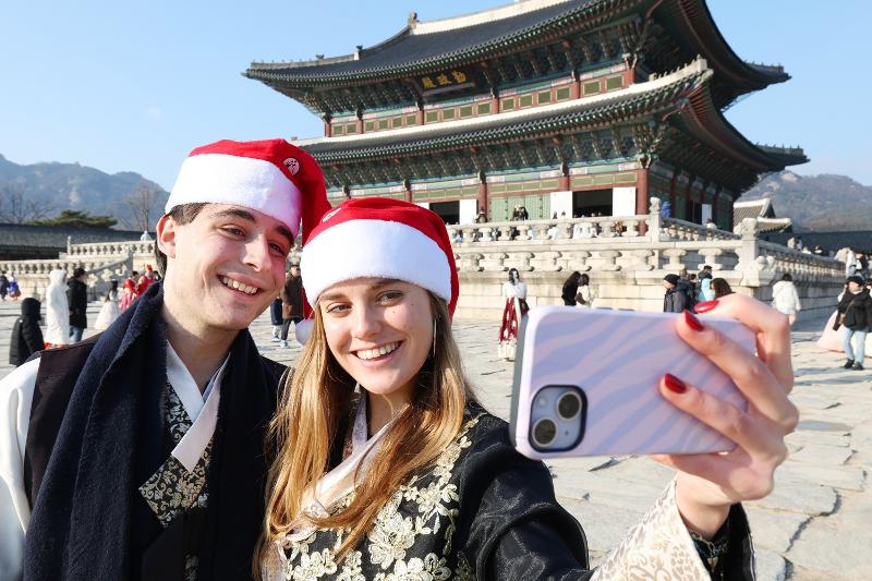 Una pareja se toma una selfi el 23 de diciembre de 2025 en el palacio Gyeongbokgung, en el distrito de Jongno-gu, en Seúl. | Lee Jeong Woo