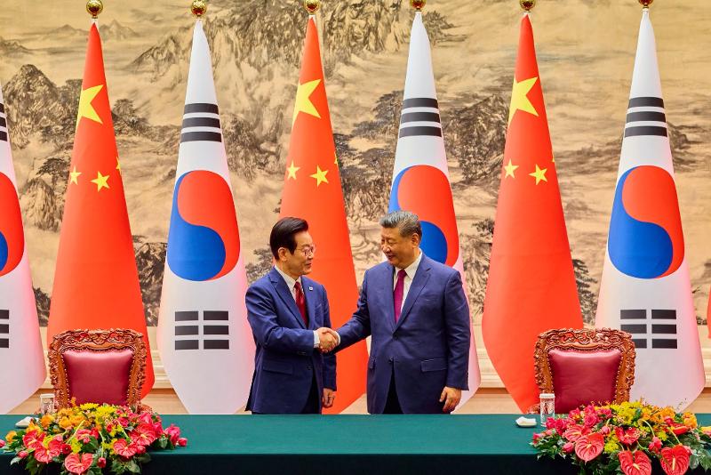 El presidente coreano, Lee Jae-myung (izq.), estrecha la mano de su homólogo chino, Xi Jinping, durante la ceremonia de firma del memorando de entendimiento (MOU, por sus siglas en inglés) entre Corea y China, celebrada el 5 de enero en el Gran Salón del Pueblo en Pekín. | Cuenta oficial dell presidente Lee Jae Myung en Facebook