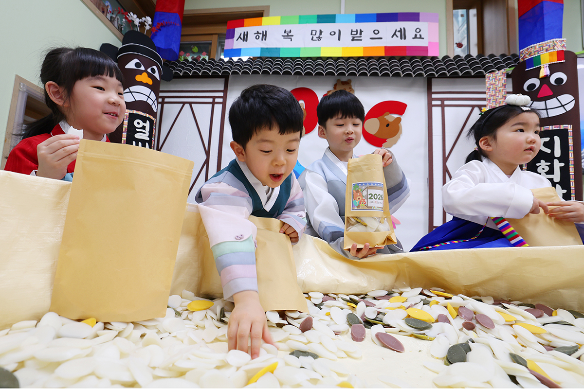 El 13 de febrero, en v&iacute;speras del A&ntilde;o Nuevo Lunar, ni&ntilde;os vestidos con el hanbok (traje tradicional coreano) colocan cuidadosamente pasteles de arroz en sobres de regalo en la Guarder&iacute;a Samjeon Chorok, en el distrito de Songpa-gu, Se&uacute;l. Esta actividad forma parte de los preparativos para compartir la tradici&oacute;n con la comunidad.