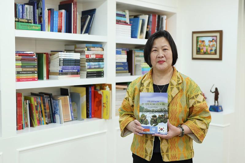 La embajadora Bernadette Therese C. Fernandez sostiene un libro sobre soldados filipinos que murieron en la Guerra de Corea, el 26 de febrero en su oficina en Seúl.
