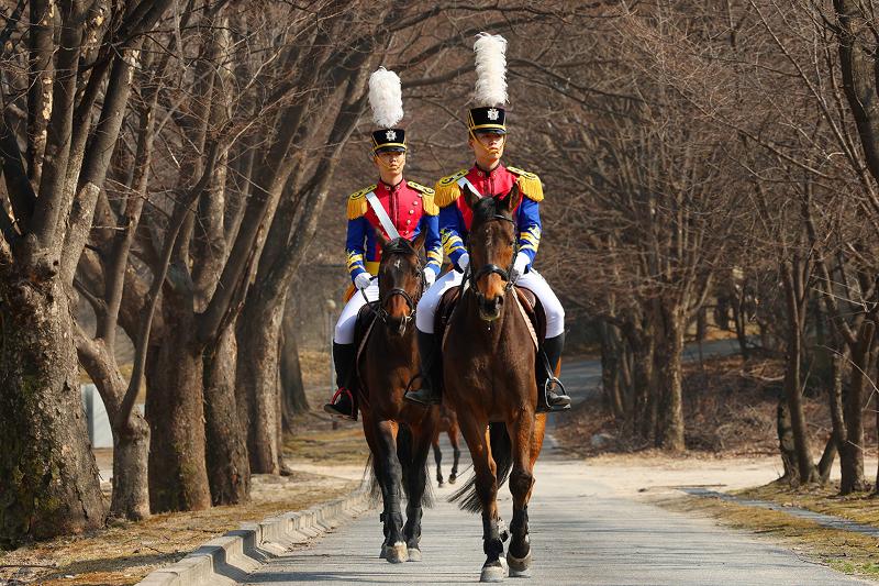 Los cadetes Her junseok y Jang won hyeok recorren juntos el campus de la KMA. Más que imponer la fuerza, la unidad de caballería proyecta la elegancia de un oficial de élite a través de la precisión en cada movimiento. Su postura inquebrantable y el equilibrio de su orden reflejan, con profunda solemnidad, el valor de la confianza que la KMA aspira a forjar.