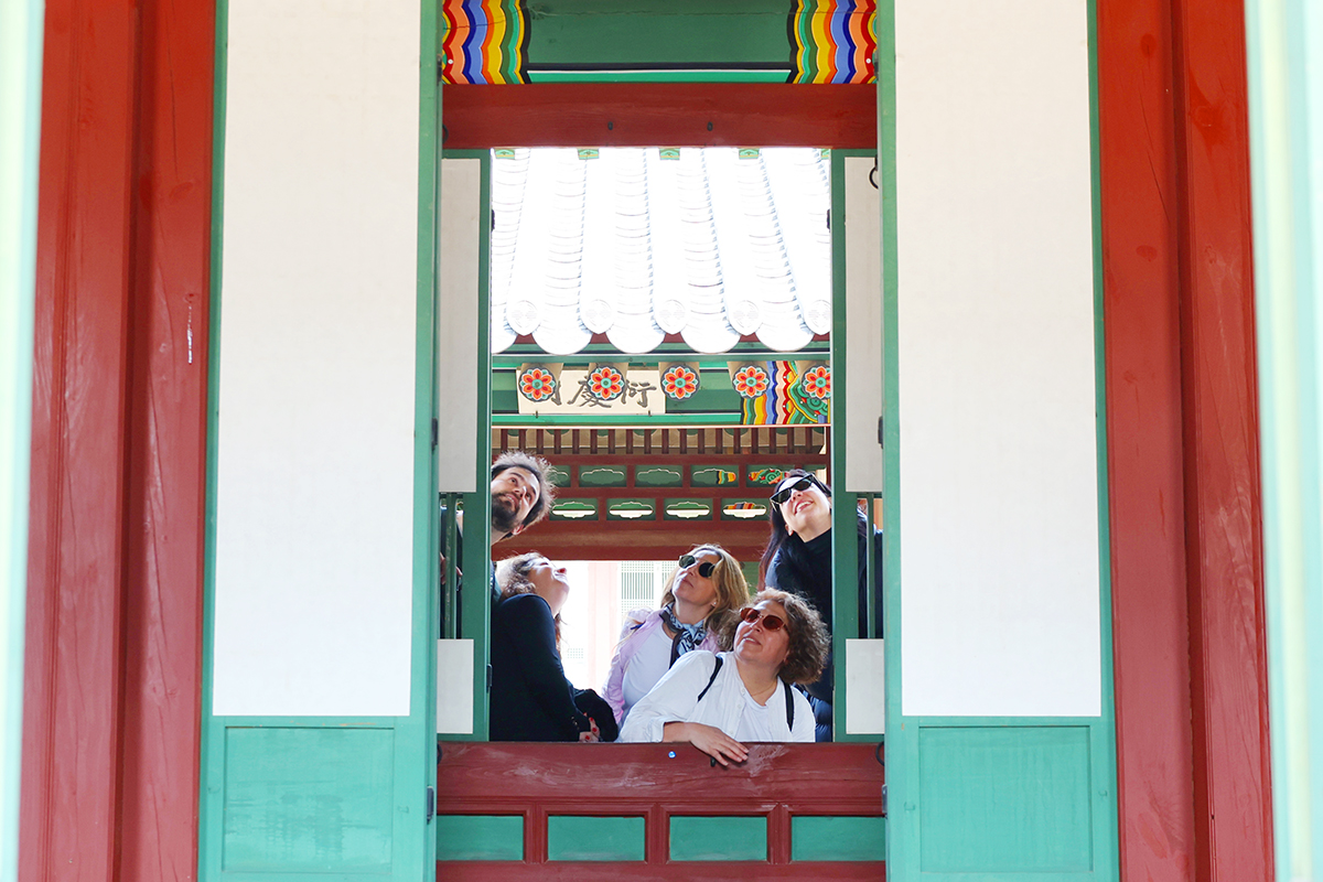 El 2 de abril, unos turistas extranjeros observan el interior de los pabellones del palacio Changdeokgung, en el distrito de Jongno-gu, en Seúl, durante el programa primaveral 
