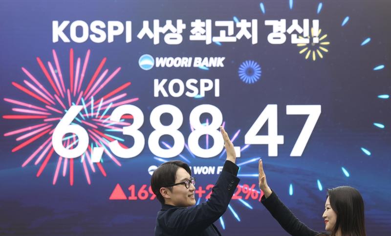 El 25 de febrero, unos empleados celebran, mientras un tablero electr&oacute;nico en la sala de operaciones del banco Woori Bank, en Se&uacute;l, muestra que el &Iacute;ndice Compuesto de Precio Burs&aacute;til de Corea (KOSPI, por sus siglas en ingl&eacute;s) alcanz&oacute; el umbral de los 6.388 puntos, por primera vez en la historia. | Agencia de Noticias Yonhap