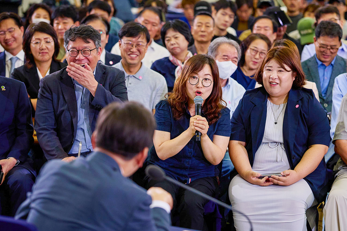 El presidente coreano Lee Jae Myung  escucha atentamente la intervención de un residente local durante la reunión de cabildo abierto 