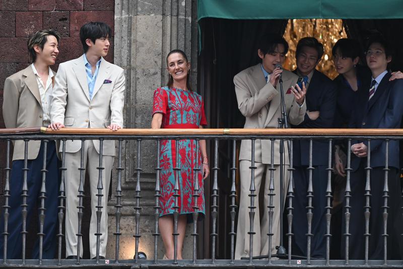 Los miembros de BTS y la presidenta mexicana Claudia Sheinbaum Pardo (3ª desde la izda.) saludan a la multitud desde el balcón del Palacio Nacional, en México. 