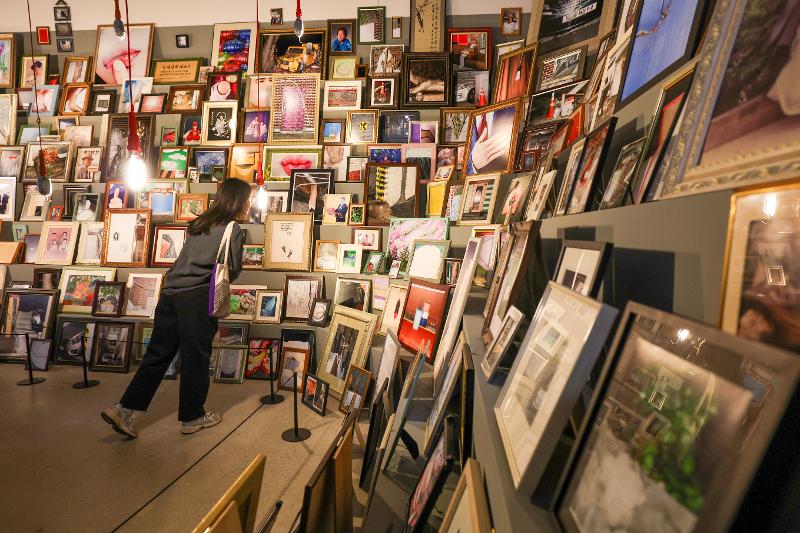 Una visitante observa fotografías exhibidas en la exposición 