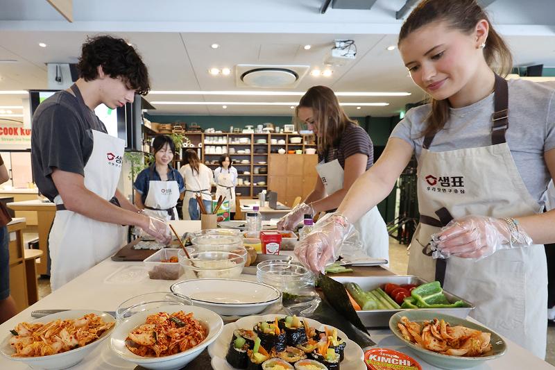 Unos estudiantes de la Universidad de Georgia, en Estados Unidos, preparan gimbap (rollos de arroz envueltos en alga seca) durante una clase de cocina coreana celebrada el 22 de mayo en el espacio culinario Sempio Urimmat, en el distrito de Jung-gu, en Seúl.