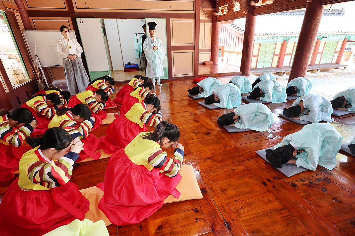 Los estudiantes de la Escuela Primaria Myeongnyun, vestidos con el traje tradicional coreano (hanbok), aprenden la etiqueta de la reverencia, el 11 de junio, en la academia confuciana Dongnaehyanggyo, en el distrito de Dongnae-gu de Busan.