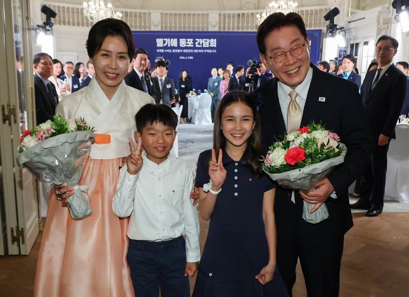 El presidente coreano Lee Jae Myung y la primera dama Kim Hea Kyung posan para una foto junto a dos niños tras recibir ramos de flores a su llegada al hotel en Bruselas, Bélgica, donde se celebró el 9 de junio (hora local) la cena con la comunidad coreana. 