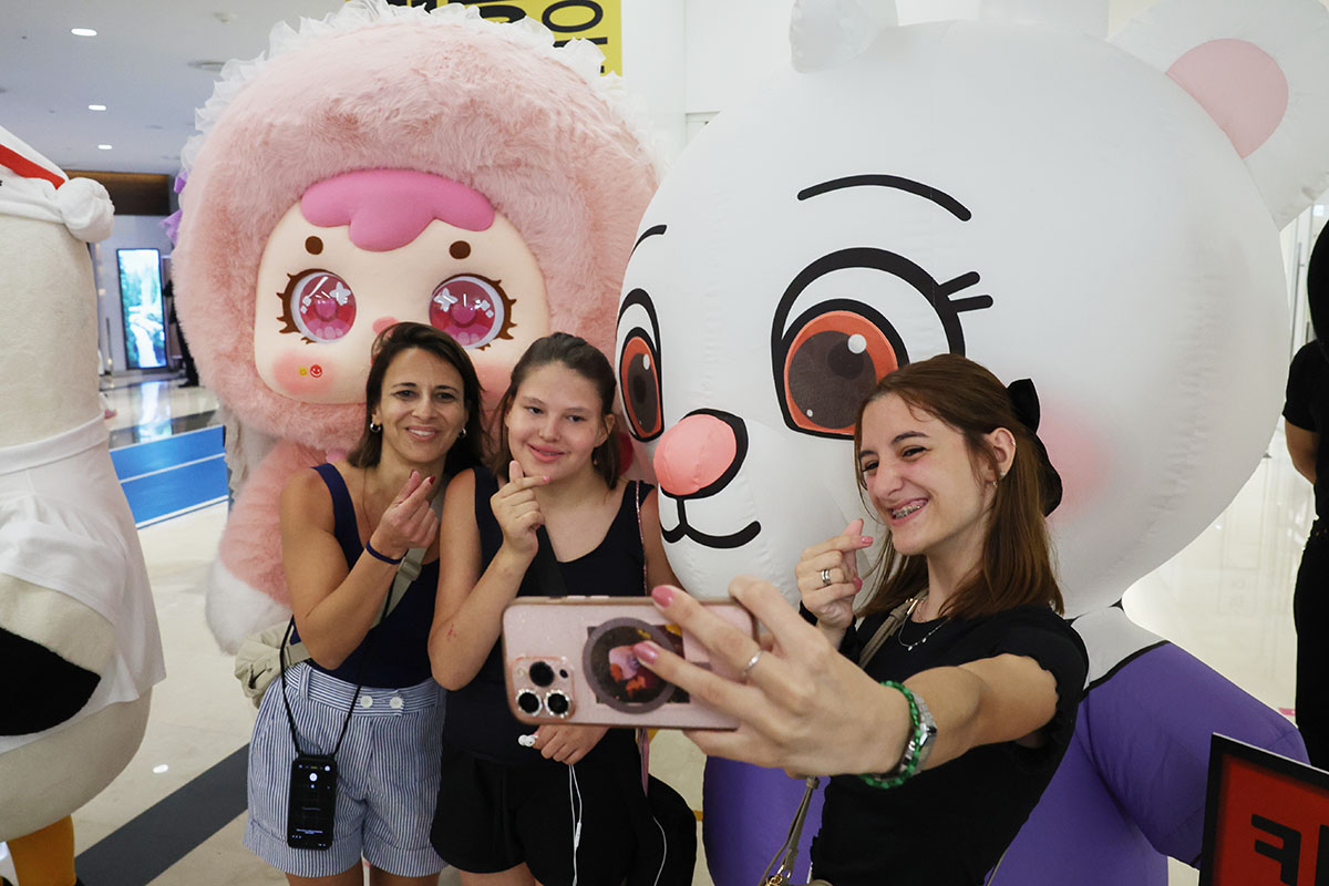 Unas extranjeras se toman una foto junto a dos figuras animadas, durante la inauguracion de la Feria de Licencias de Personajes de Corea, el 16 de julio, en el centro de convenciones COEX, ubicado en el distrito de Gangnam-gu, en Seúl.
