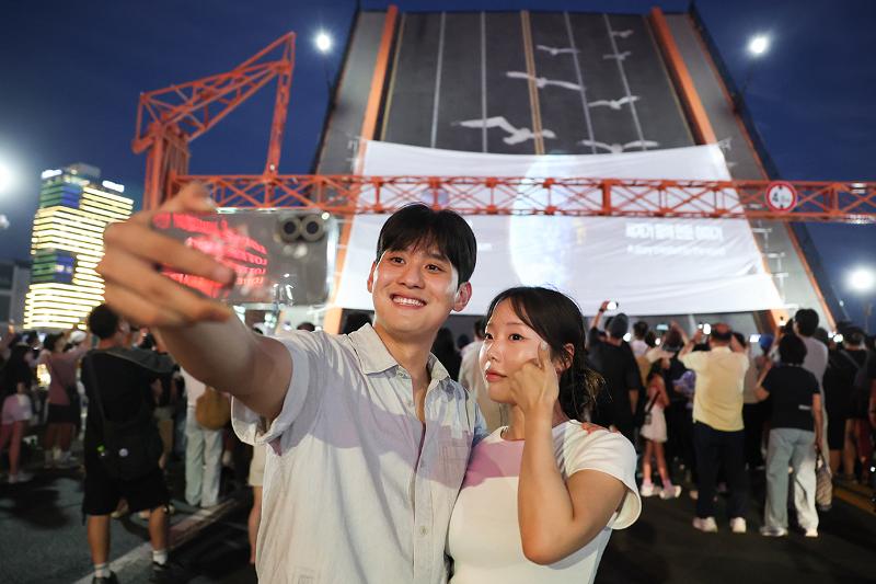 Unos ciudadanos se toman una foto con el puente Yeongdodaegyo de fondo, durante el evento 