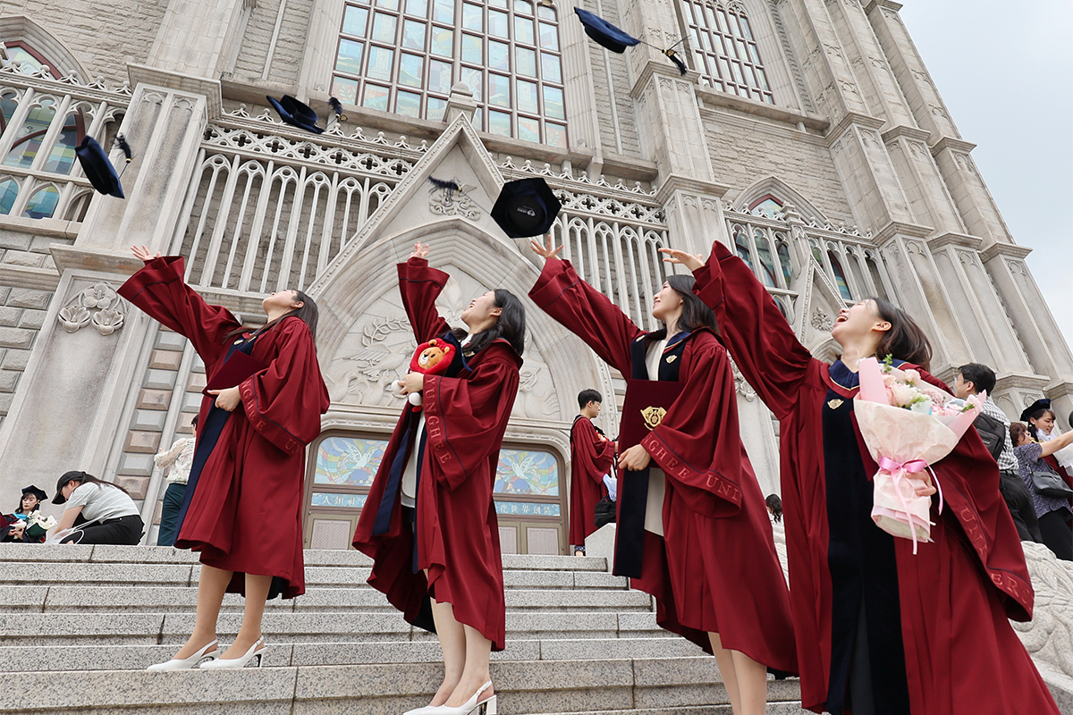 Un grupo de reci&eacute;n graduadas celebra el cierre de su etapa universitaria lanzando al un&iacute;sono sus togas y birretes al cielo, el 19 de agosto, en la Universidad de Kyung Hee del distrito de Dongdaemun, Se&uacute;l.