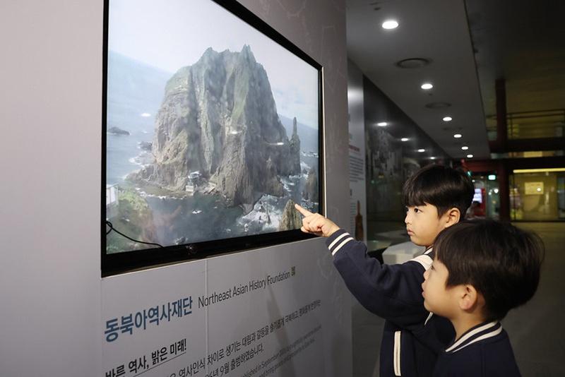 Unos niños observan los islotes de Dokdo, en una transmisión en vivo en una pantalla de la Sala de Exposición Permanente de Dokdo, ubicada en la estación de Gwanghwamun, en el distrito de Jongno-gu, en Seúl, el 24 de octubre de 2025, en vísperas del Día de Dokdo. Esta jornada conmemorativa, que se celebra cada 25 de octubre, fue establecida con el propósito de reafirmar la voluntad del pueblo coreano de proteger los islotes de Dokdo y proclamar, tanto dentro como fuera del país, que dichos islotes pertenecen a la República de Corea. | Korea.net DB