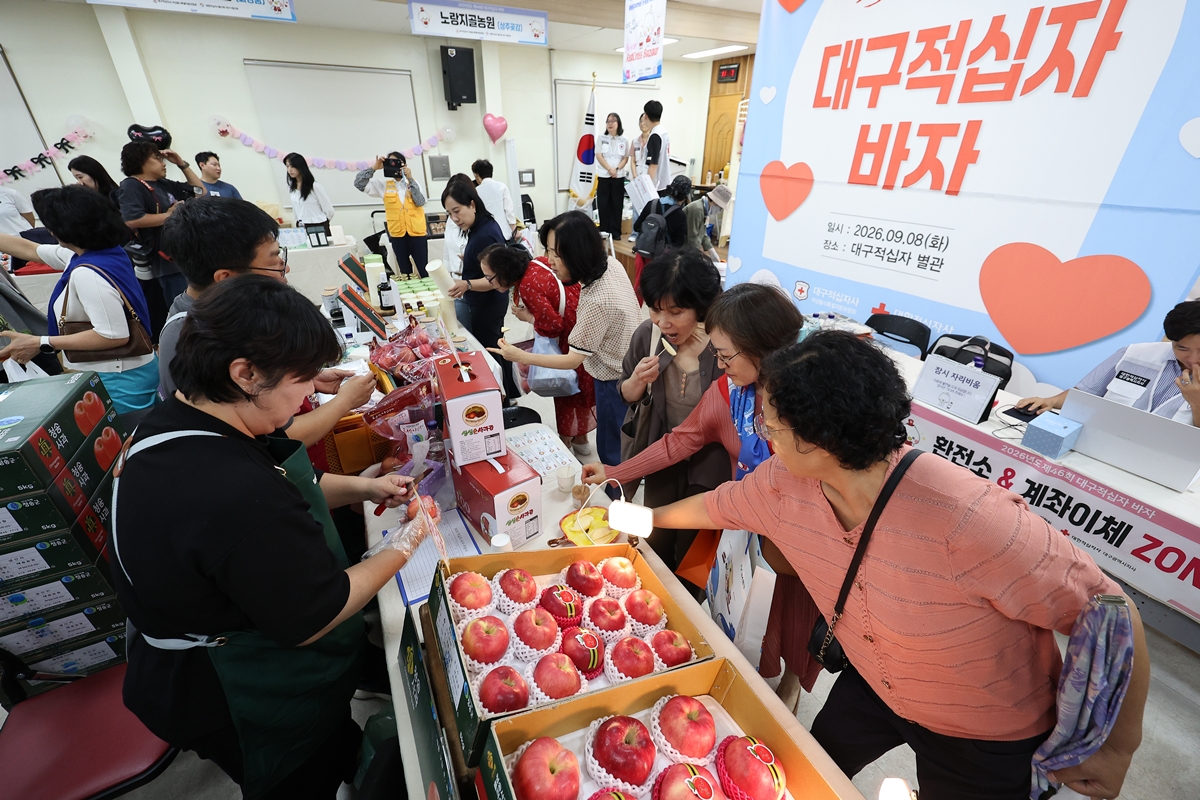 Unas ciudadanas degustan una muestra de manzanas en un puesto del 46º Bazar de la Cruz Roja, celebrado el 8 de septiembre en el distrito de Jung-gu, en Daegu