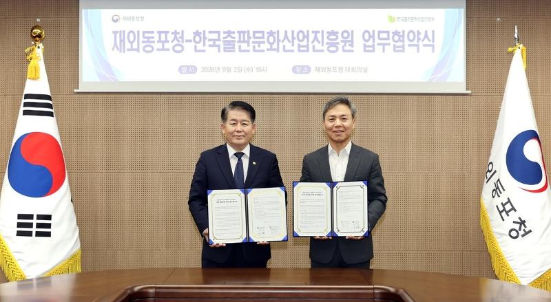 El director de la Agencia para los Coreanos en el Exterior (OKA, por sus siglas en inglés), Kim Kyung-hyup (izda.), y el presidente de la Agencia de Promoción de la Industria Editorial de Corea (KPIPA), Kim Seung-su, sostienen las copias del memorando de entendimiento (MOU) firmado el 2 de septiembre en la sala principal de conferencias de la OKA, en Songdo, en el distrito de Yeonsu-gu, en la ciudad de Incheon. | Agencia para los Coreanos en el Exterior