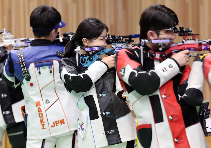 Los tiradores coreanos Ban Hyo-jin (centro) y Park Ha-jun (derecha) disparan hacia la diana en la final mixta por equipos de rifle de aire a 10 metros, el 22 de septiembre en el Campo de Tiro de Aichi, en Jap&oacute;n.