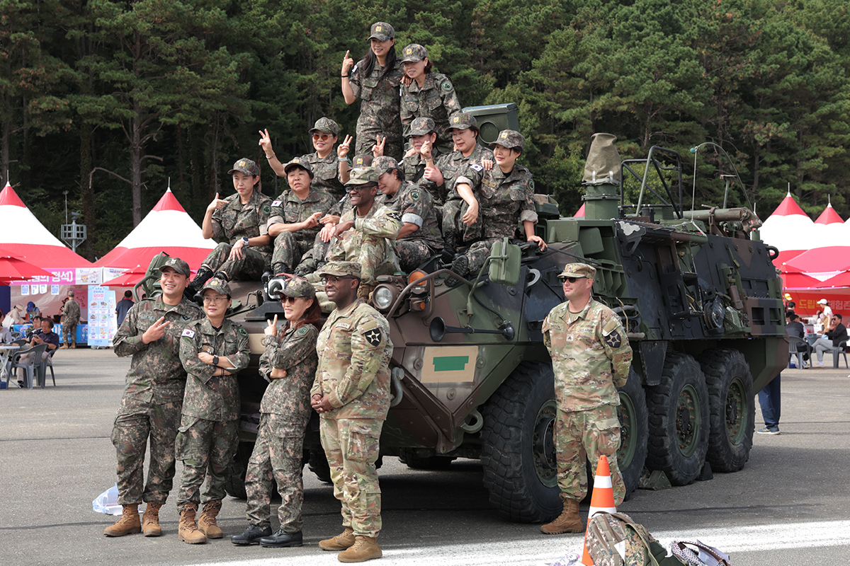 Unos ciudadanos posan sobre un vehículo blindado junto a efectivos de las tropas estadounidenses desplegadas en Corea durante el 16º Festival Cultural Militar de Gyeryong, celebrado el 1 de octubre en la ciudad homónima, en la provincia de Chungcheongnam-do, coincidiendo con el Día de las Fuerzas Armadas.
