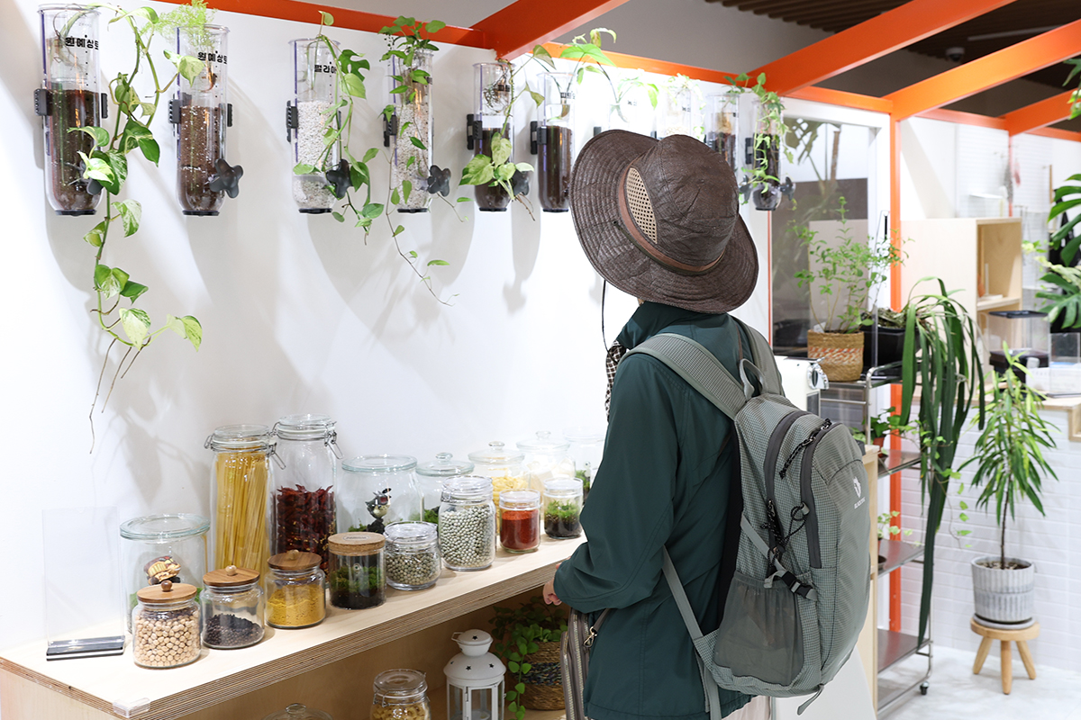 Una visitante observa una estancia acondicionada con elementos vegetales durante la exposici&oacute;n 
