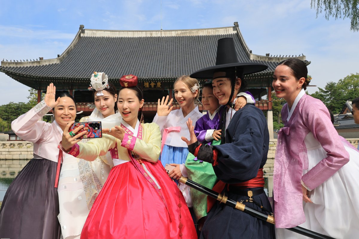 Varios participantes coreanos y extranjeros vestidos con trajes tradicionales posan para una foto de recuerdo en el palacio Gyeongbokgung, en Se&uacute;l, el 19 de octubre, durante la 