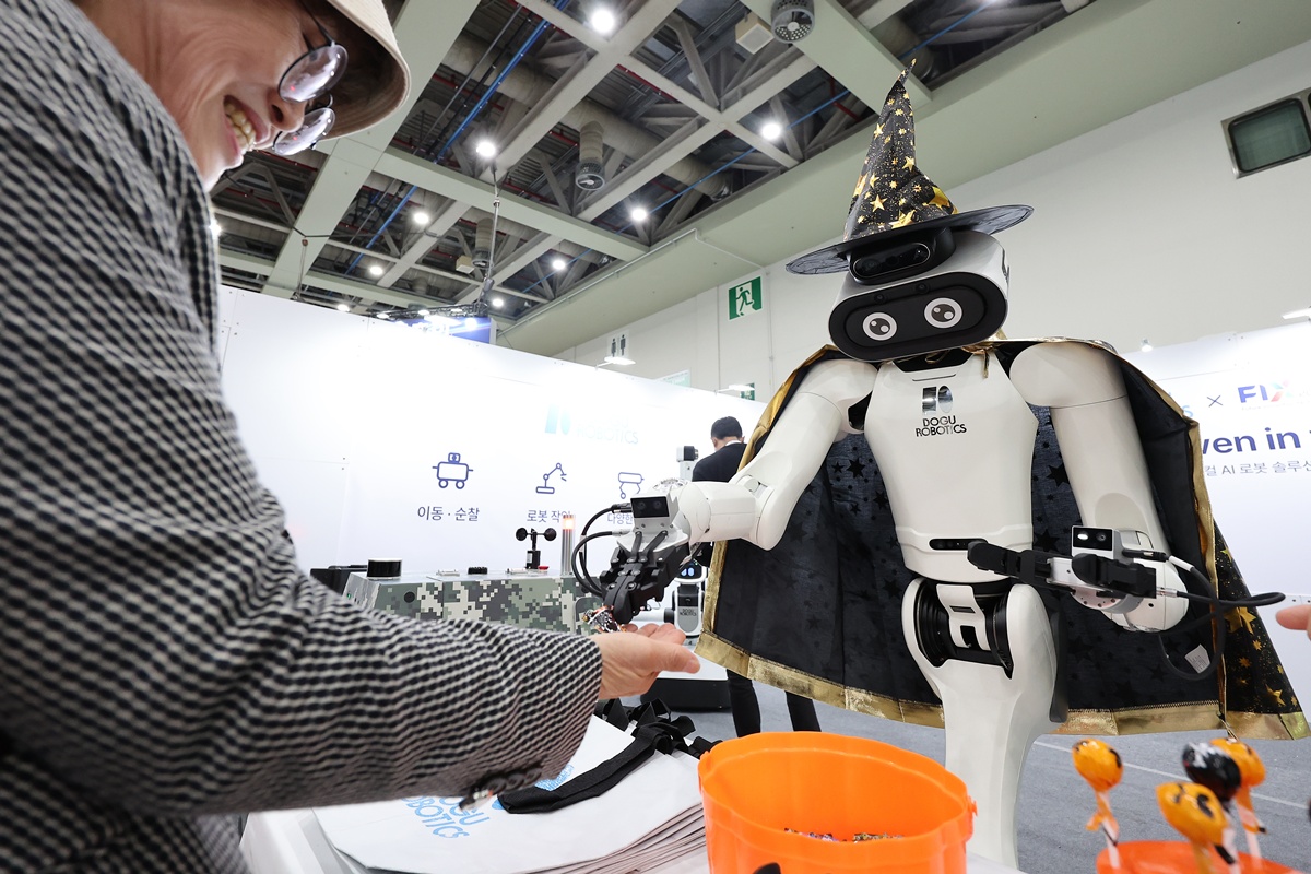 Un visitante interact&uacute;a con un robot disfrazado de bruja durante la inauguraci&oacute;n de la Exposici&oacute;n de Tecnolog&iacute;as de Innovaci&oacute;n del Futuro 2026 (FIX, por sus siglas en ingl&eacute;s), celebrada el 21 de octubre en el centro de convenciones EXCO, ubicado en el distrito de Buk-gu, en Daegu.